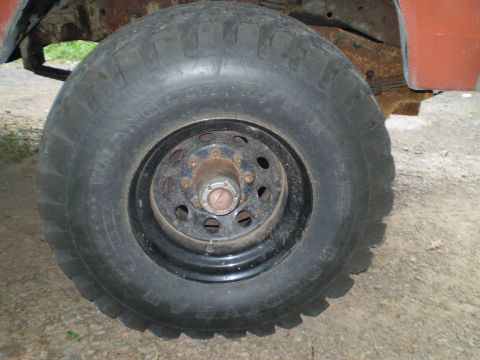 1979 Ford Bronco - This image shows a close-up of a vehicle's wheel, hub, and suspension components, with a portion of the body visible.