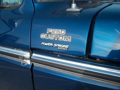 1978 Ford Bronco - Close-up of a blue truck's fender showing the F250 CUSTOM POWER STROKE DIESEL badging.