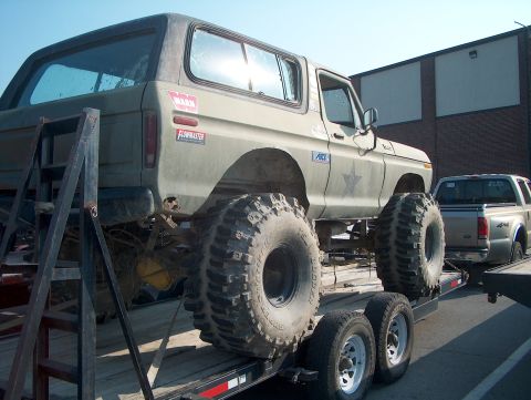 1978 Ford Bronco - Modified 1978 Ford Bronco with oversized tires being transported on a trailer.