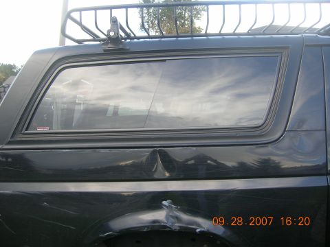 1996 Ford Bronco - The vehicle has a roof rack and visible damage to the rear body panel.