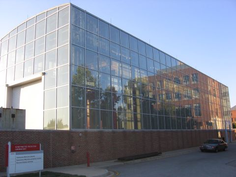 2000 Ford Crown Victoria - A 2000 Ford Crown Victoria is parked next to a modern building with a glass facade.