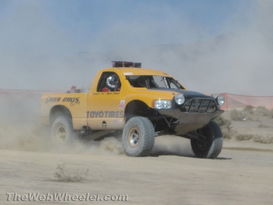 Yellow off-road truck with Toyo Tires decal racing in desert