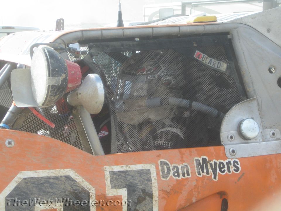 Close-up of an orange off-road race vehicle's caged engine bay labeled "Dan Myers"
