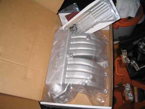 1989 Ford Bronco - Unboxed Edelbrock performance parts, including an intake manifold and valve covers, sit ready for installation.