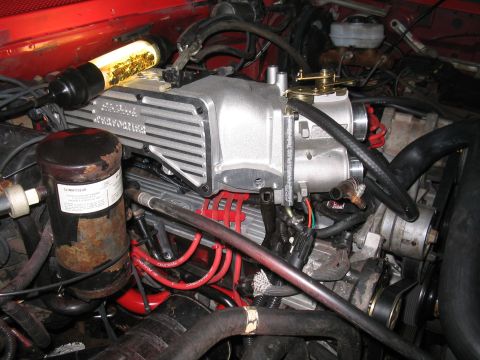 1989 Ford Bronco - Close-up view of a vehicle's engine bay, highlighting an aftermarket supercharger and associated components.