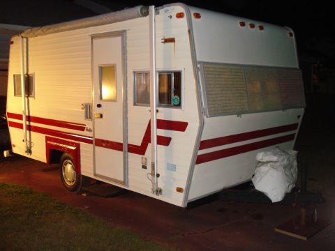 1994 Ford Bronco - This camper trailer features a white exterior with red racing stripes and an extended awning.