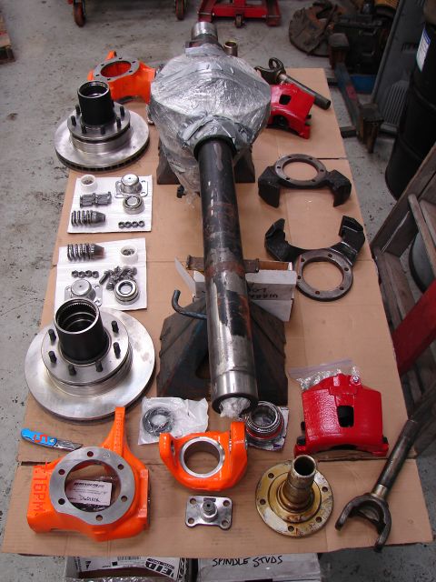 1989 Ford Bronco - Various parts for a Dana 60 front axle are displayed, including brake components and axle shafts.