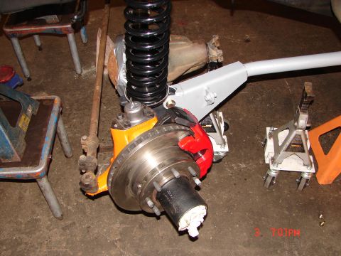 1989 Ford Bronco - Close-up of a vehicle's front axle assembly, showing suspension and brake components.
