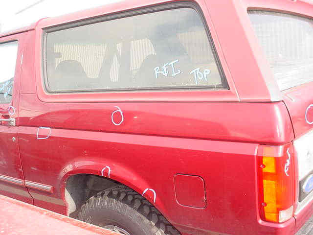 Red Ford Bronco side view, showing damage marks and 'R&I Top' written on the rear window