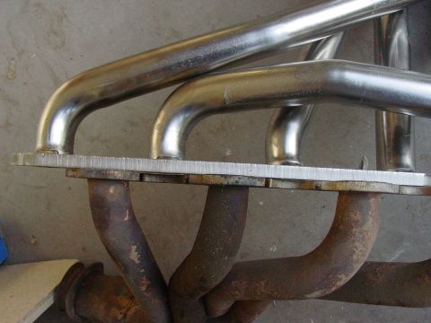1979 Ford Bronco - Close-up view of an exhaust manifold, showing a mix of polished and rusted metal components.