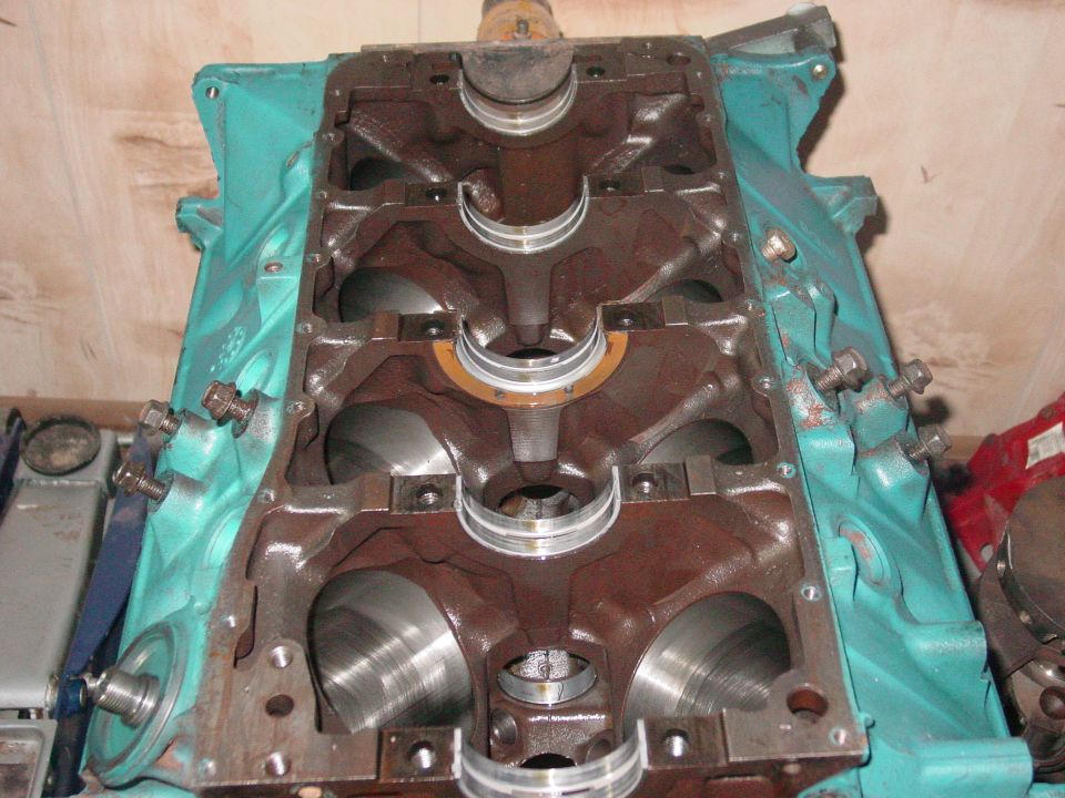 Engine block with crankshaft bearings visible. It's teal on the outside and rusty brown inside