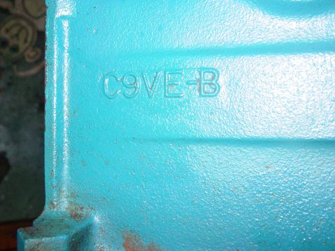 1979 Ford Bronco - A close-up view of a cast metal part, painted turquoise, with a stamped identification code.