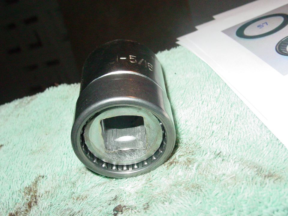 Close-up of a socket wrench part with "1-5/16" etched on it, resting on a green cloth