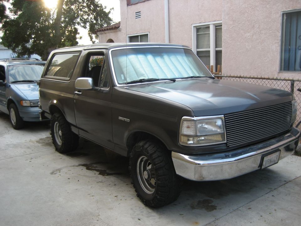Charcoal gray two-door Ford Bronco SUV parked on driveway, 3/4 front view