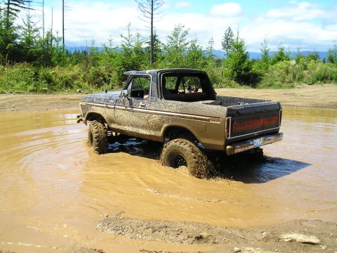 1989 Ford Bronco - This classic Ford Bronco navigates a muddy obstacle on a sunny day.