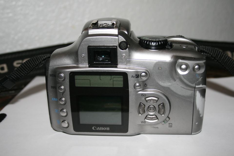 Rear view of a silver Canon digital camera with LCD screen and buttons