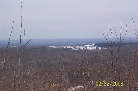 1978 Ford Bronco - A wide shot captures a town in a valley, viewed from a wooded hillside on an overcast day.