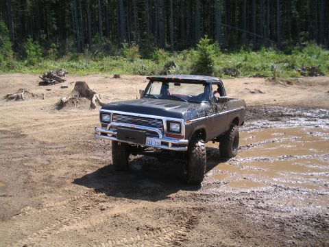 1989 Ford Bronco - This lifted 1979 Ford F-150 is shown off-road in a muddy area with trees in the background.