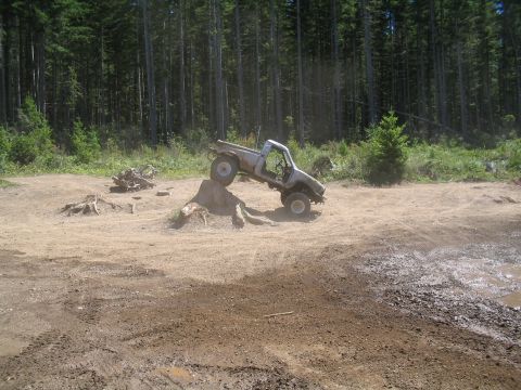 1989 Ford Bronco - A modified pickup truck navigates an obstacle course in a wooded area.