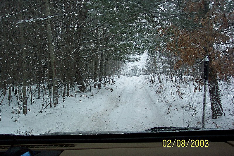 Interior view of a vehicle driving on a snowy forest road