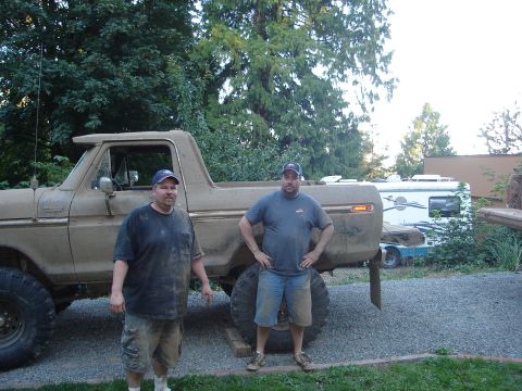 1989 Ford Bronco - Two men pose with a heavily modified, mud-covered 1978 Ford F-150 pickup truck.