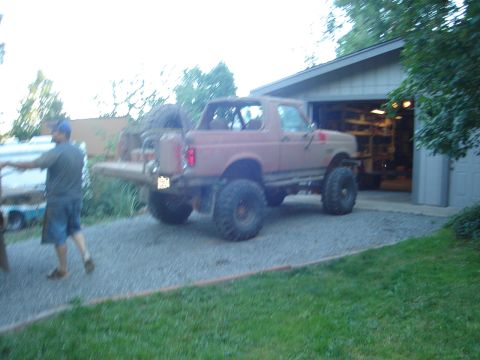 1989 Ford Bronco - A heavily modified Ford Bronco sits outside a garage, ready for off-road adventures.