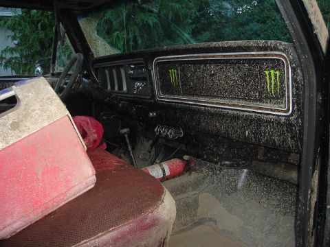 1989 Ford Bronco - The interior of this vehicle is covered in mud, with prominent Monster Energy decals on the dashboard.