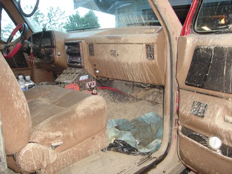 1989 Ford Bronco - The interior of this vehicle is heavily covered in mud, obscuring most details.