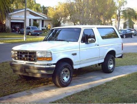 1995 Ford Bronco - White 1995 Ford Bronco parked on a residential street in front of a house.
