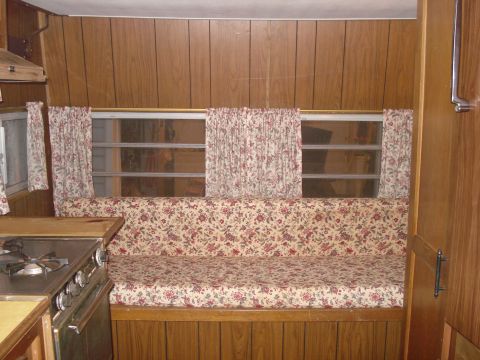 1994 Ford Bronco - Interior view of a camper showing a couch, windows with curtains, and a kitchen area.