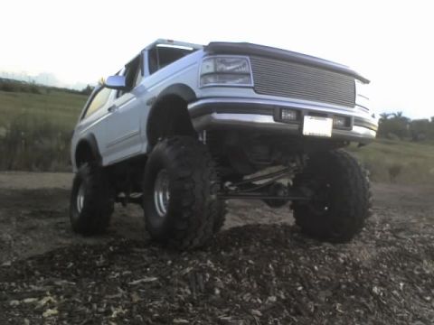 1995 Ford Bronco - This modified Ford Bronco is shown from a low angle, highlighting its off-road capabilities.
