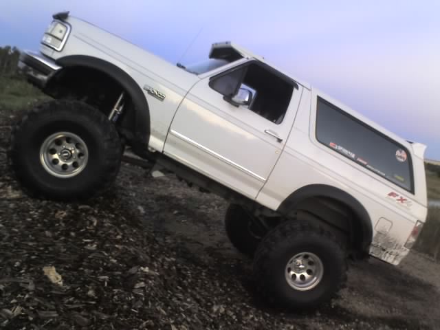 1995 Ford Bronco with large tires on a dirt incline