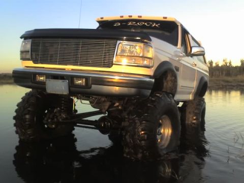 1995 Ford Bronco - This lifted 1995 Ford Bronco, sporting a 'D-ROCK' decal, navigates through shallow water.