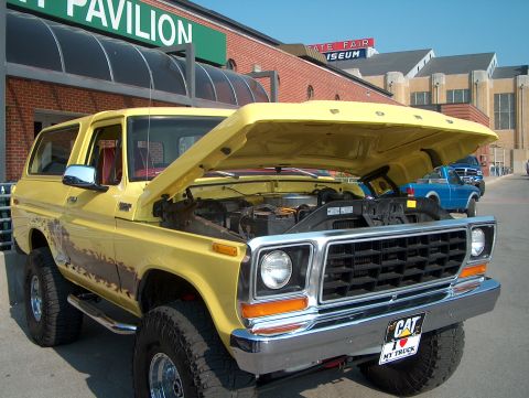 1978 Ford Bronco - This yellow 1978 Ford Bronco is parked with its hood open, showing the engine bay.