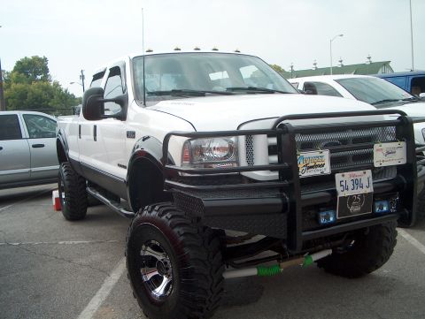 1978 Ford Bronco - This white Ford F-250 Super Duty pickup truck is modified with a large grille guard and oversized tires.