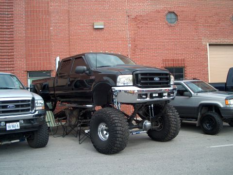 1978 Ford Bronco - This lifted black Ford F-250 Super Duty pickup truck is parked next to other vehicles.