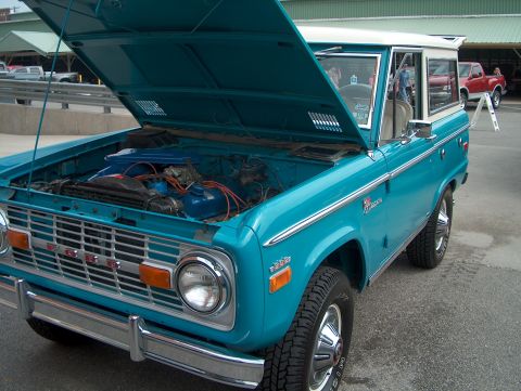 1978 Ford Bronco - A turquoise 1978 Ford Bronco is displayed with its hood open, revealing the engine compartment.
