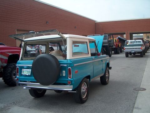 1978 Ford Bronco - Teal and white 1978 Ford Bronco parked in a line with other vehicles.