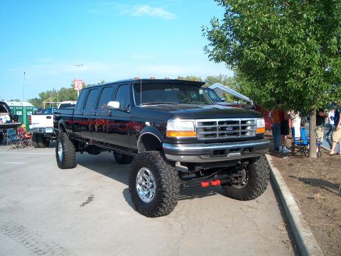 1978 Ford Bronco - This heavily modified black pickup truck features an extended cab and large off-road tires, suggesting a custom build rather than a stock v…