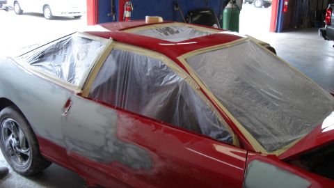 1996 Ford Probe - This vehicle is being prepped for paint, with plastic sheeting covering the windows and masking tape around the edges.