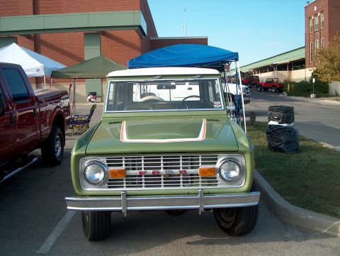 1978 Ford Bronco - A green 1978 Ford Bronco is parked at an outdoor event with other vehicles visible.