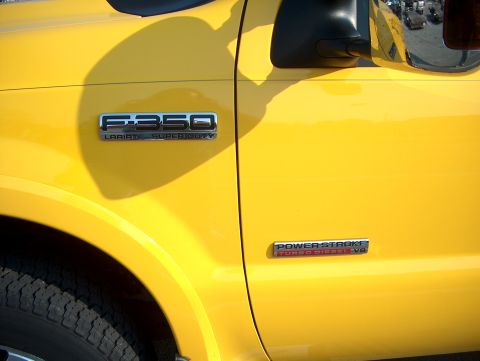 1978 Ford Bronco - Close-up of a yellow Ford F-350 Lariat Super Duty truck, showing the fender, door, and side mirror.