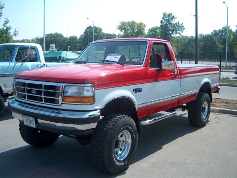 1978 Ford Bronco - A two-tone pickup truck is parked outdoors on a sunny day.