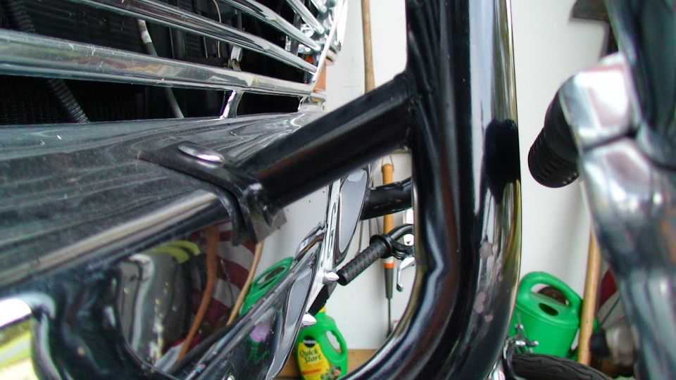 Chrome grille and black metal frame of a 1979 Ford F-250, close-up front view