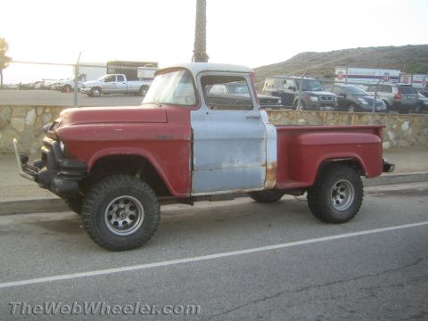 1968 Ford Mustang - This older model pickup truck has a red cab and bed, with a gray door and fender.