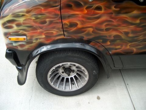 1978 Ford Bronco - A van features a custom flame paint job on its side, with a close-up on the front wheel and fender area.