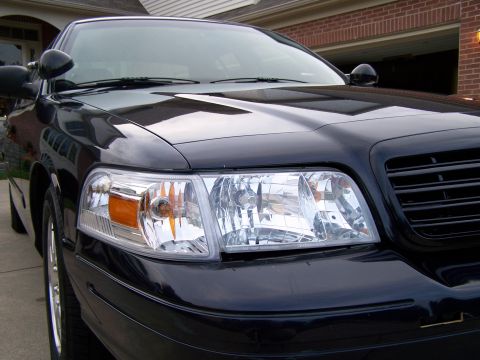 2003 Ford Crown Victoria - Front view of a black 2003 Ford Crown Victoria, focusing on the headlights and grille.