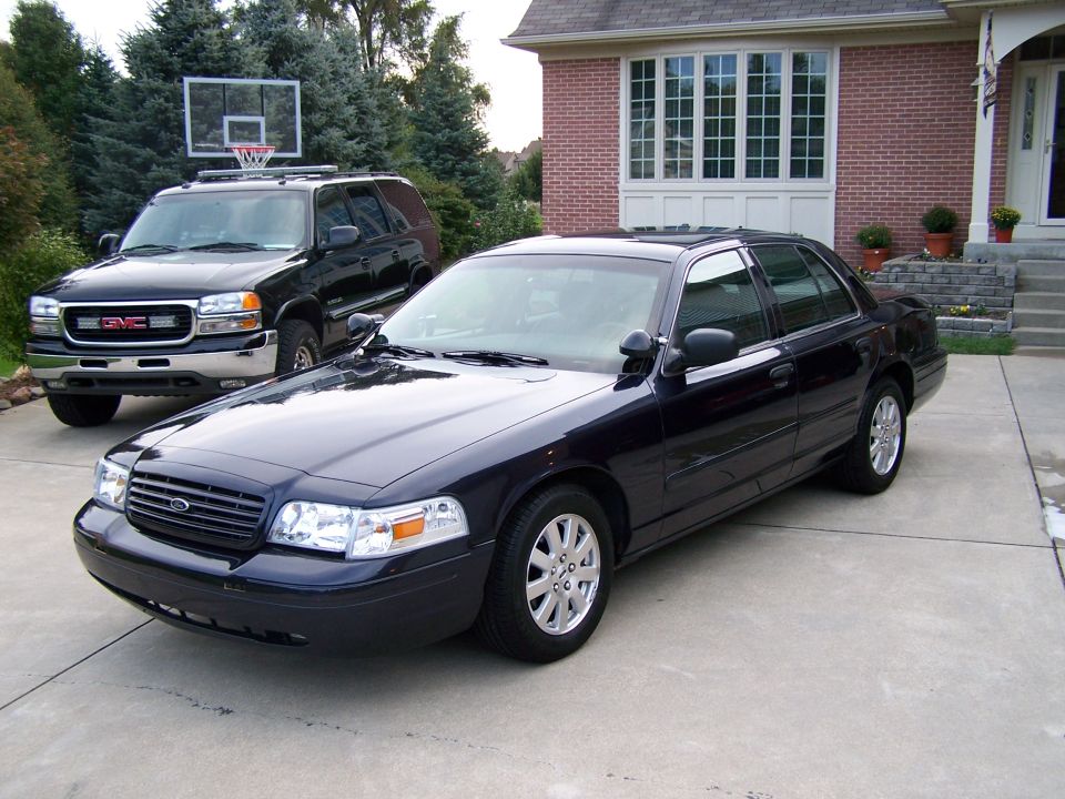 Dark blue 2003 Ford Crown Victoria sedan parked in driveway