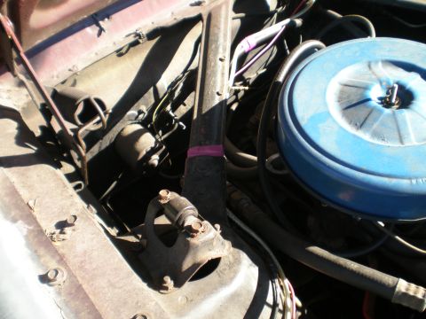 1966 Ford Mustang - The engine bay of a vehicle is shown, with various components and wiring visible under the hood.