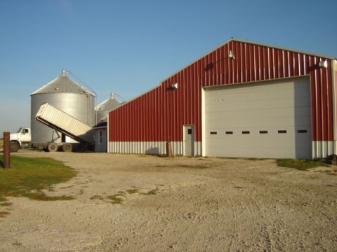 1992 Ford Bronco - A truck and trailer are positioned near a barn and grain silos on a clear day.